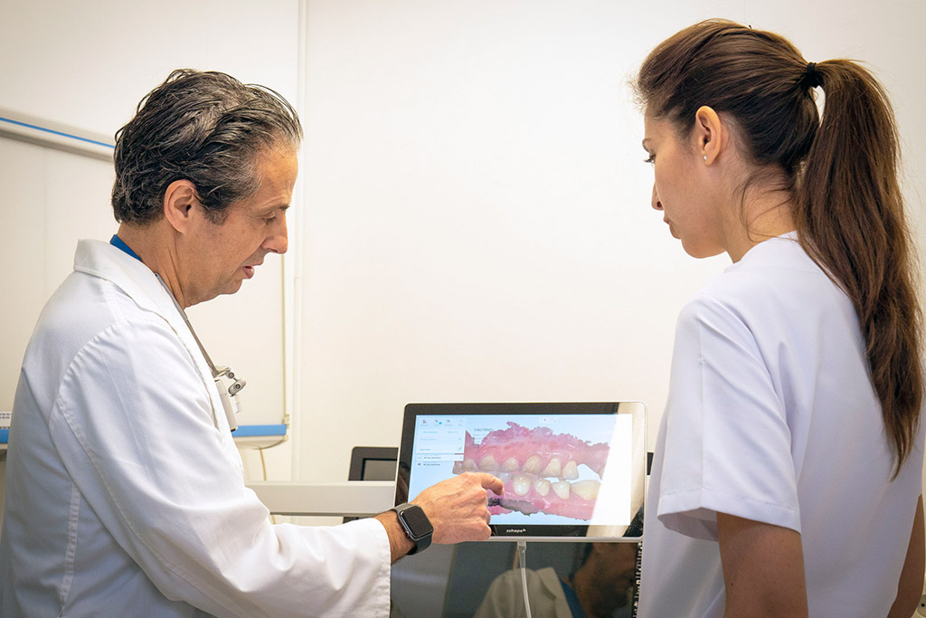 El doctor muestra en la pantalla las manchas en dientes del paciente
