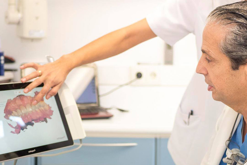 El Dr. Javier Sola revisa la imágenes de un paciente con agenesia dental