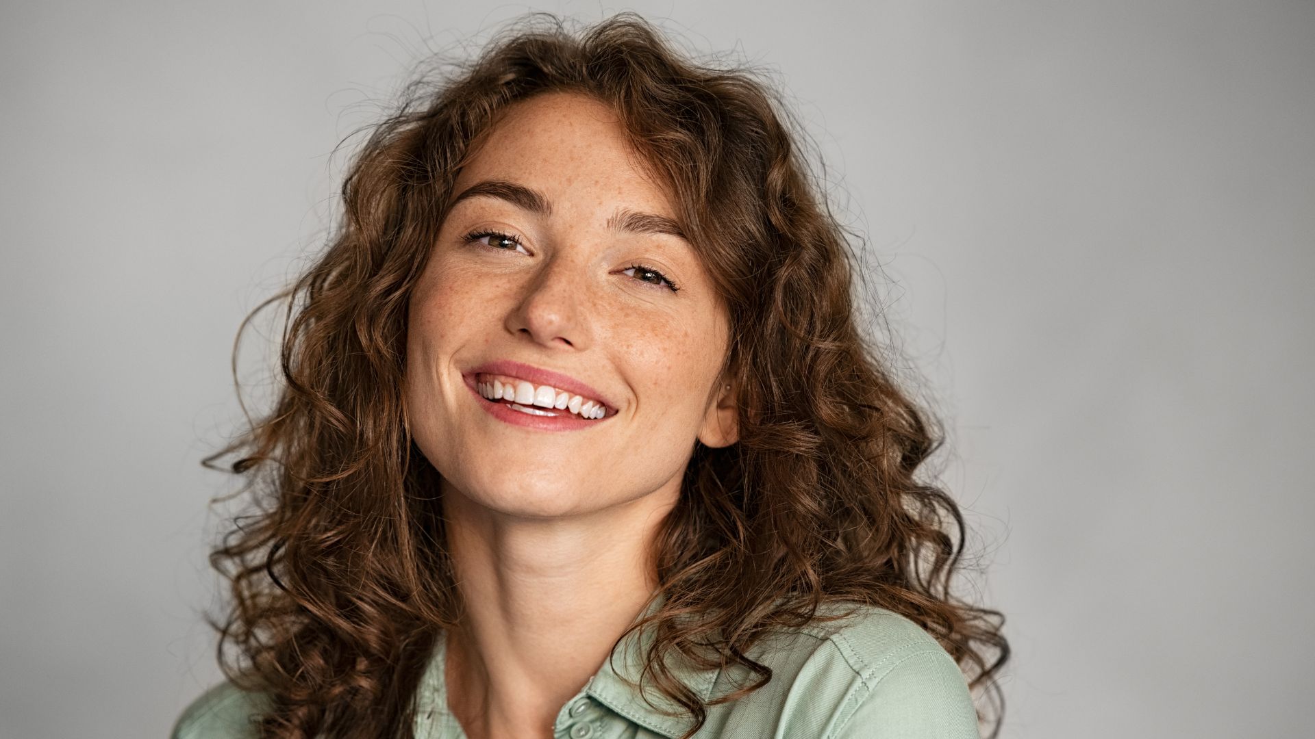 Chica con pelo rizado y sonrisa blanca